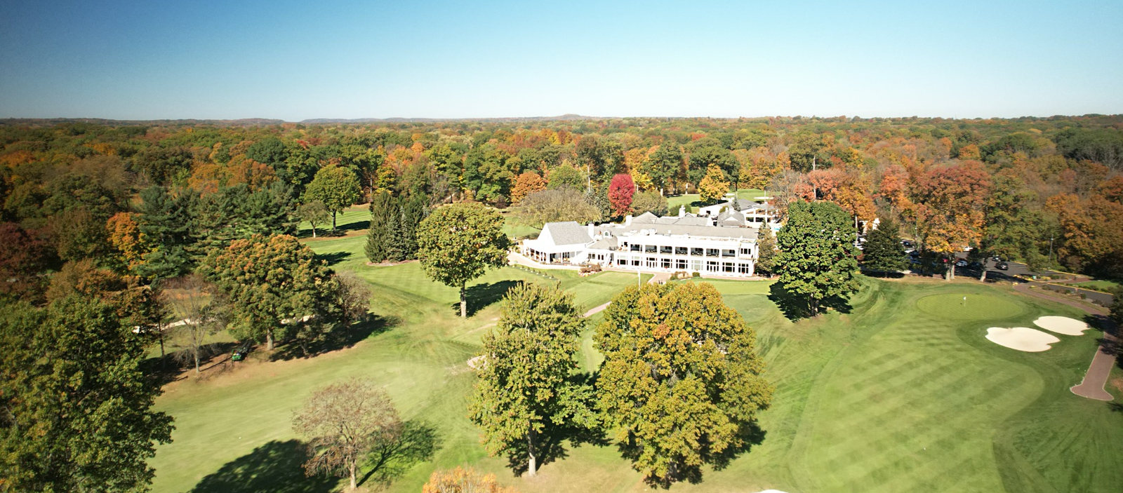 Aerial photograph of a private country club clubhouse, golf course and autumn landscape